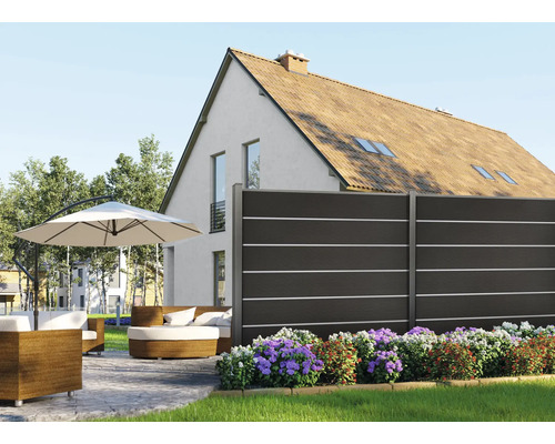 Gartenszene mit Zaun, Gartenmöbeln und Sonnenschirm vor einem Haus