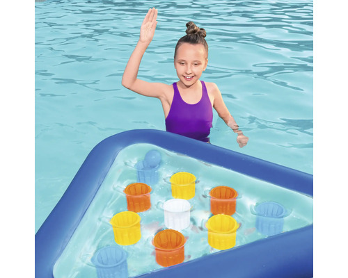 Mädchen im Pool mit aufblasbarem Spielbrett und bunten Eimern