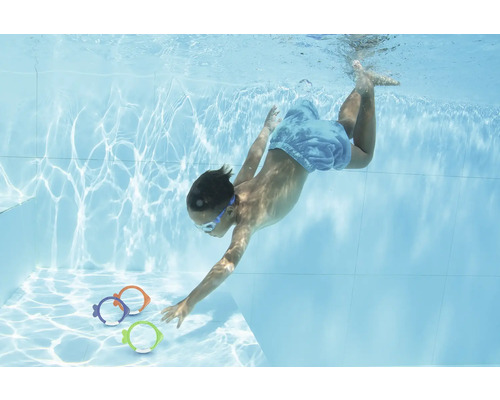 Enfant plongeant dans la piscine pour attraper des poissons jouets