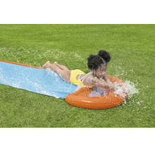 Mädchen rutscht auf einer Wasserrutsche im Garten.