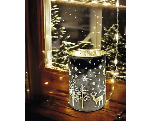 Photophore décoratif avec motifs de sapins et de cerfs pour une ambiance chaleureuse.