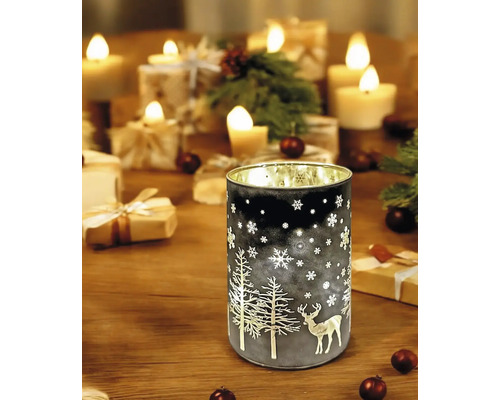 Lanterne photophore décorative avec motifs hivernaux sur une table avec des bougies et des cadeaux