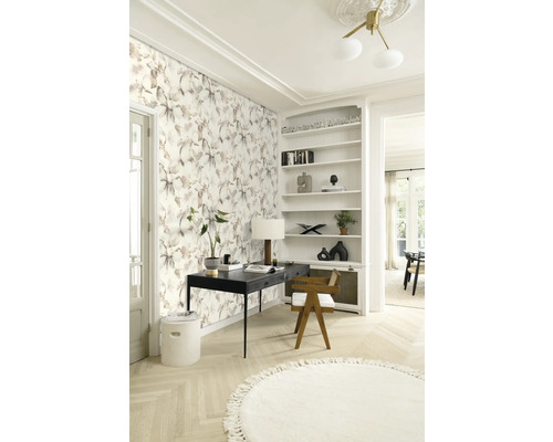 Pièce lumineuse avec papier peint floral, bureau, chaise et bibliothèque pour une ambiance claire et organisée.