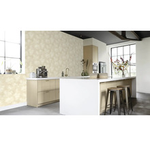 Cuisine claire avec papier peint à motifs, îlot de cuisine et tabourets de bar.