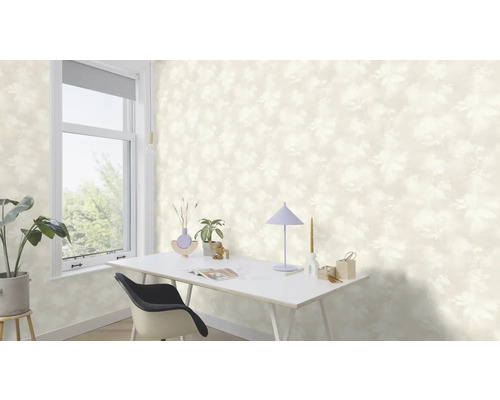 Pièce claire avec papier peint à motifs floraux, bureau et fenêtre.