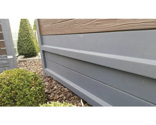 Nahaufnahme eines Zaunelements mit Holzoptik und grauen Paneelen