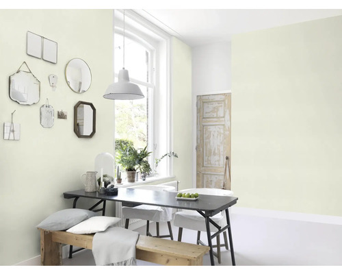 Pièce lumineuse avec table à manger, chaises, banc et miroirs au mur