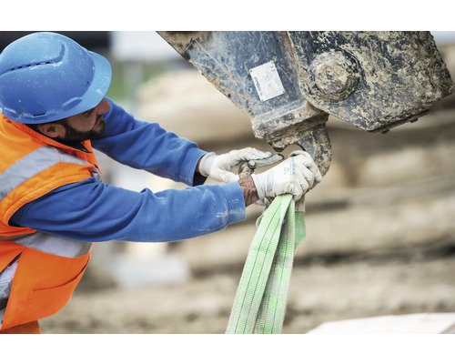 Bauarbeiter befestigt Hebeband an Baumaschine