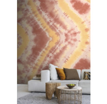 Wohnzimmer mit gemusterter Tapete, Sofa und Beistelltischen.