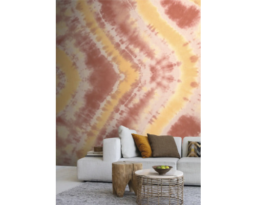 Wohnzimmer mit gemusterter Tapete, Sofa und Beistelltischen.