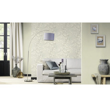 Salon avec canapé, lampadaire et papier peint fleuri pour une ambiance lumineuse