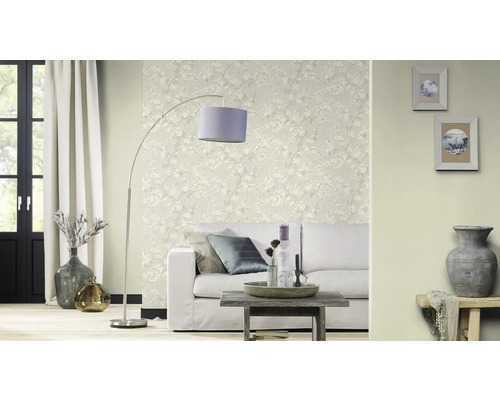 Salon avec canapé, lampadaire et papier peint fleuri pour une ambiance lumineuse