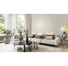 Salon lumineux avec papier peint à motifs, canapé et table basse.