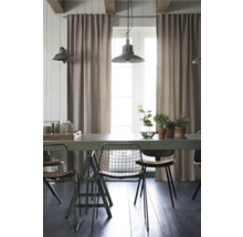 Salle à manger avec table, chaises, rideaux et suspensions.