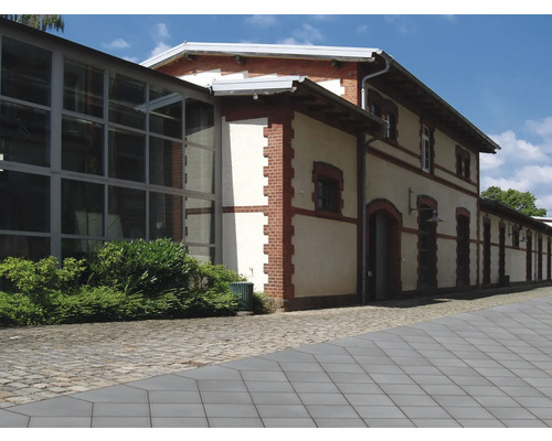 Aussenansicht eines mehrstöckigen Gebäudes mit Ziegeldetails und grossen Fenstern