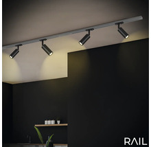 Éclairage sur rail avec quatre spots au plafond dans une pièce.