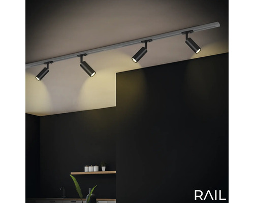Éclairage sur rail avec quatre spots au plafond dans une pièce.