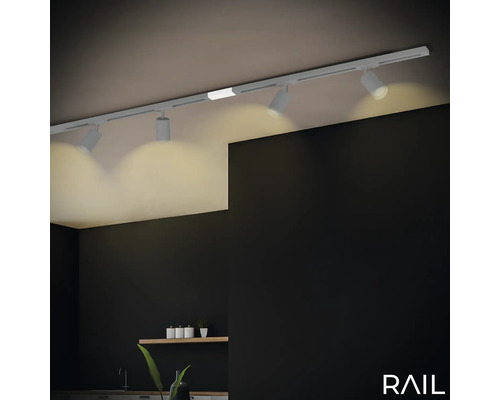 Deckenleuchte mit Spots an einer Schiene in einem Raum.