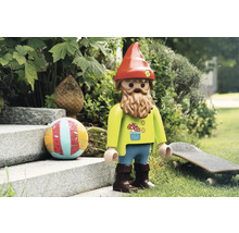 Spielzeugfigur eines Gartenzwergs mit Bart, Mütze und Dekorationen im Garten