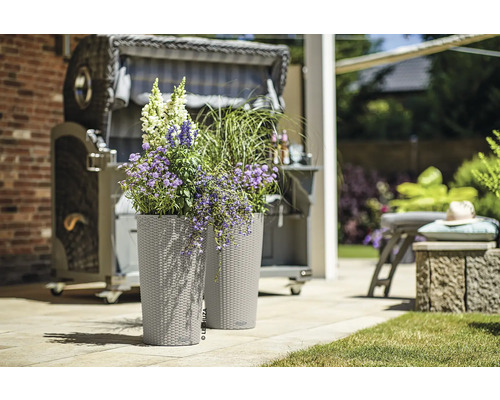 Deux jardinières avec des fleurs et une chaise de plage en arrière-plan.