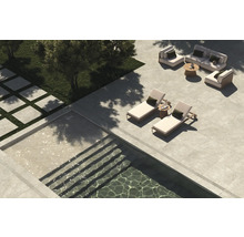 Blick auf eine Terrasse mit Steinfliesen, Pool und Sitzbereich