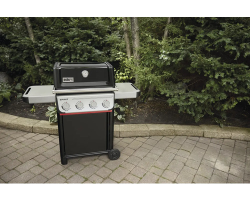 Weber Spirit Gasgrill mit Seitentischen vor Gartenkulisse