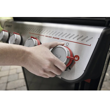 Nahaufnahme einer Person, die den Drehknopf eines Weber Spirit Gasgrills bedient