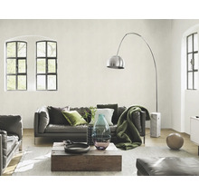 Wohnzimmer mit Ledersofa, Holztisch, Stehlampe und großen Fenstern für eine helle Atmosphäre.