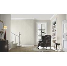 Wohnzimmer mit Sessel, Lampe und Bücherregal