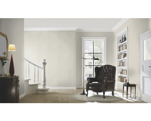 Wohnzimmer mit Sessel, Lampe und Bücherregal