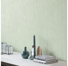 Dekorative Wand mit Strukturtapete und Wohnaccessoires wie Vasen, Kerzen und Büchern