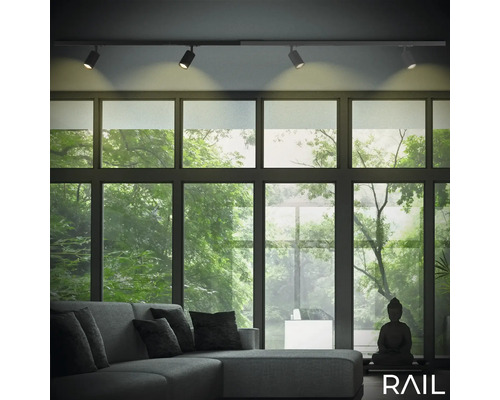 Wohnzimmer mit Schienensystemleuchten, Sofa und Fensterfront mit Blick ins Grüne