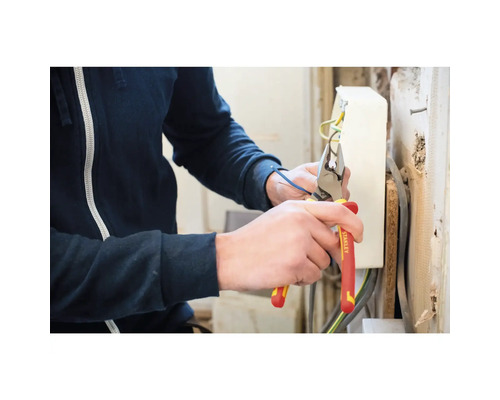 Eine Person schneidet mit einer Stanley Kombizange ein Kabel.