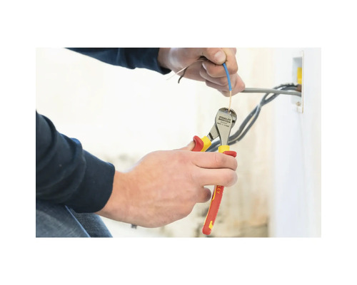 Une personne coupe un câble avec une pince coupante