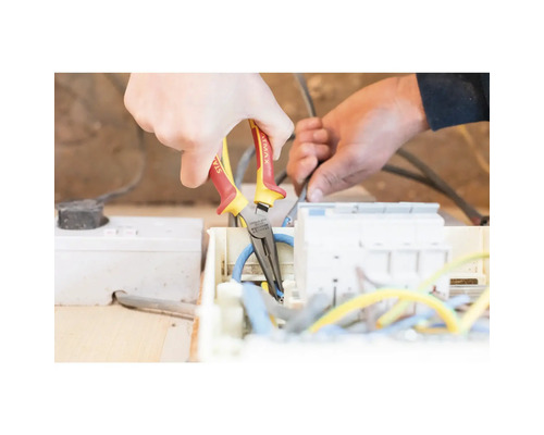 Électricien travaillant sur des câbles électriques avec une pince à bec.