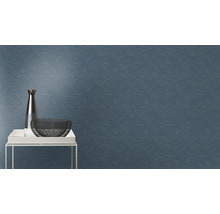 Nahaufnahme einer blauen Wandtapete mit einem sich wiederholenden, halbkreisförmigen Muster, zusammen mit einer Vase und einer Schale auf einem Tisch.