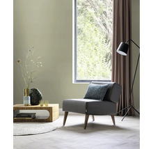 Wohnzimmer mit Sessel, Couchtisch, Stehlampe und Fenster für eine helle Atmosphäre