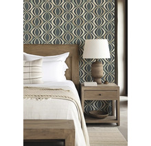 Schlafzimmer mit Bett, Nachttischlampe und gemusterter Tapete