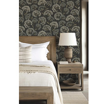 Schlafzimmer mit Bett, Nachttisch und floral gemusterter Tapete