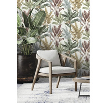 Wohnraum mit tropischer Blättertapete, Sessel, Zimmerpflanze und Teppich