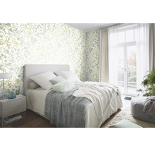 Schlafzimmer mit floral gemusterter Tapete, Bett und Tagesdecke