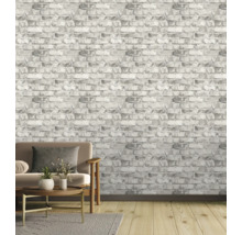 Salon avec papier peint brique grise, canapé, tapis et parquet