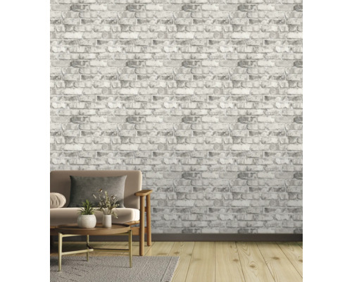 Salon avec papier peint brique grise, canapé, tapis et parquet