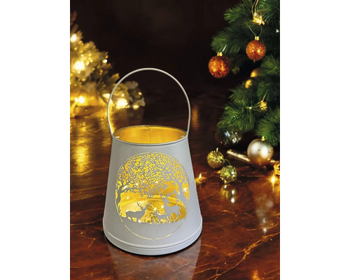 Lanterne décorative avec motif de cerf et motif d''arbre à côté d''un arbre de Noël décoré.