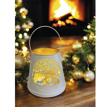 Lanterne décorative avec motif de cerf et poignée devant une cheminée et un sapin de Noël.