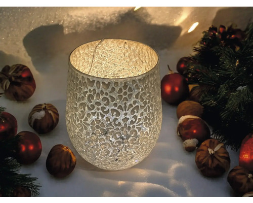 Lanterne décorative en verre avec ornements, entourée de boules et de noix