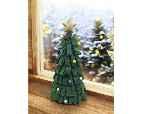 Dekorativer Weihnachtsbaum mit Stern auf einem Holztisch vor einem Fenster