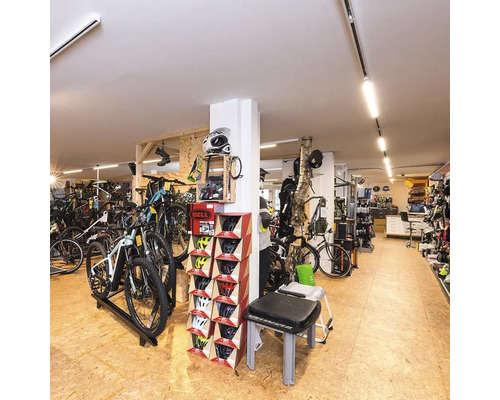 Fahrradgeschäft Innenansicht mit Fahrrädern, Helmen und Zubehör