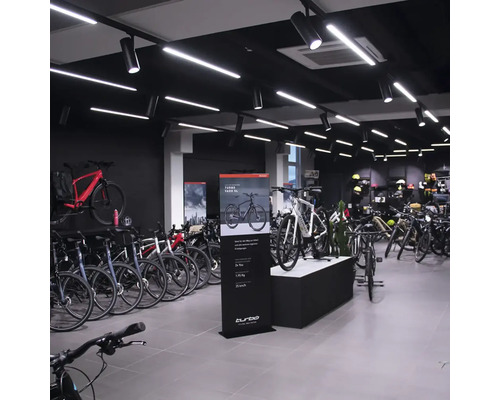 Innenansicht eines Fahrradgeschäfts mit ausgestellten Fahrrädern und Verkaufsständern