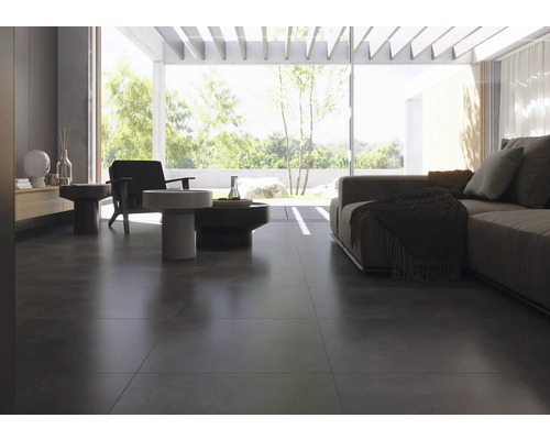 Espace de vie lumineux avec revêtement de sol en carrelage foncé, canapé et fauteuils